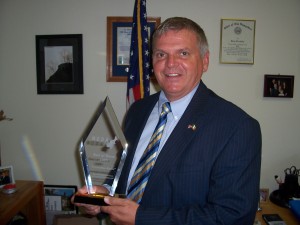 NH Division of Economic Development Interim Director Roy Duddy proudly displays the NEDA Award.