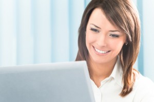 Happy smiling businesswoman with computer at office