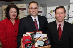 New Hampshire Division of Economic Development Business Recruiter Cindy Harrington (l.) and State Business Development Manager Michael Bergeron (r.) flank GoumetGiftBaskets.com Director of Corporate Sales Jason Bergeron as they prepare to ship Valentine's Day gift baskets to a dozen of the Granite State's hottest Massachusetts prospects.